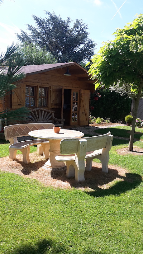 Le jardin avec la table et les chaises en pierres, roulotte de Nainville dans l'Essonne