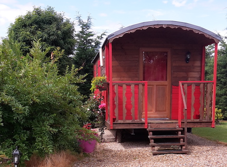 roulotte rouge avec son petit jardin et sa terrasse