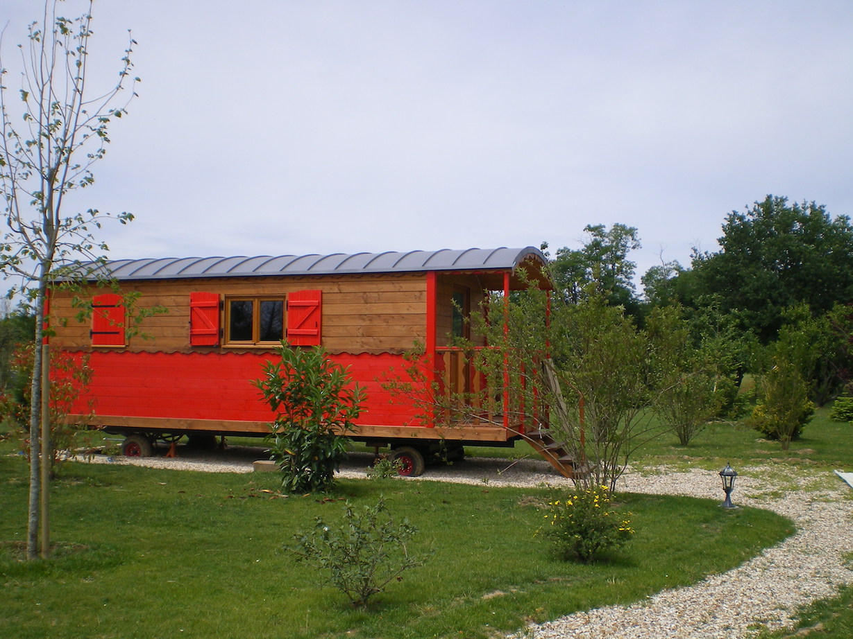 roulotte rouge au bord de la forêt